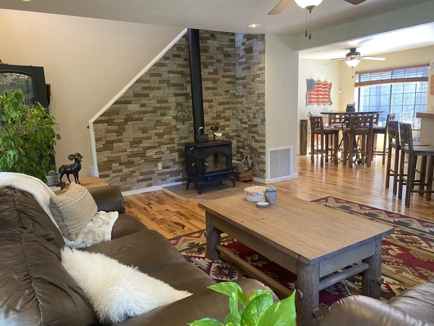 Great room with a stone wood-burning fireplace and dining for the group