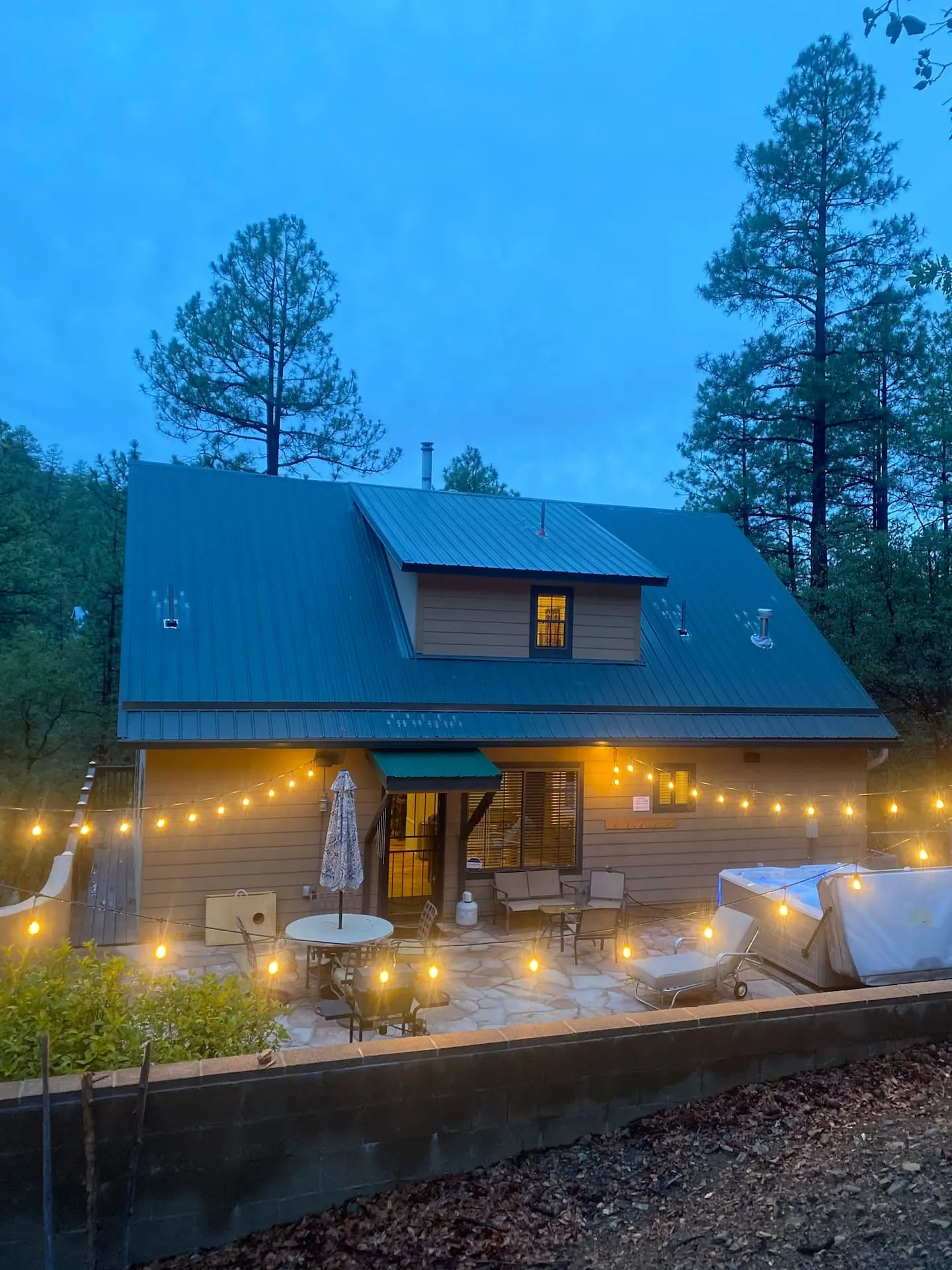 The Groom Creek Getaway cabin glowing under string lights at dusk
