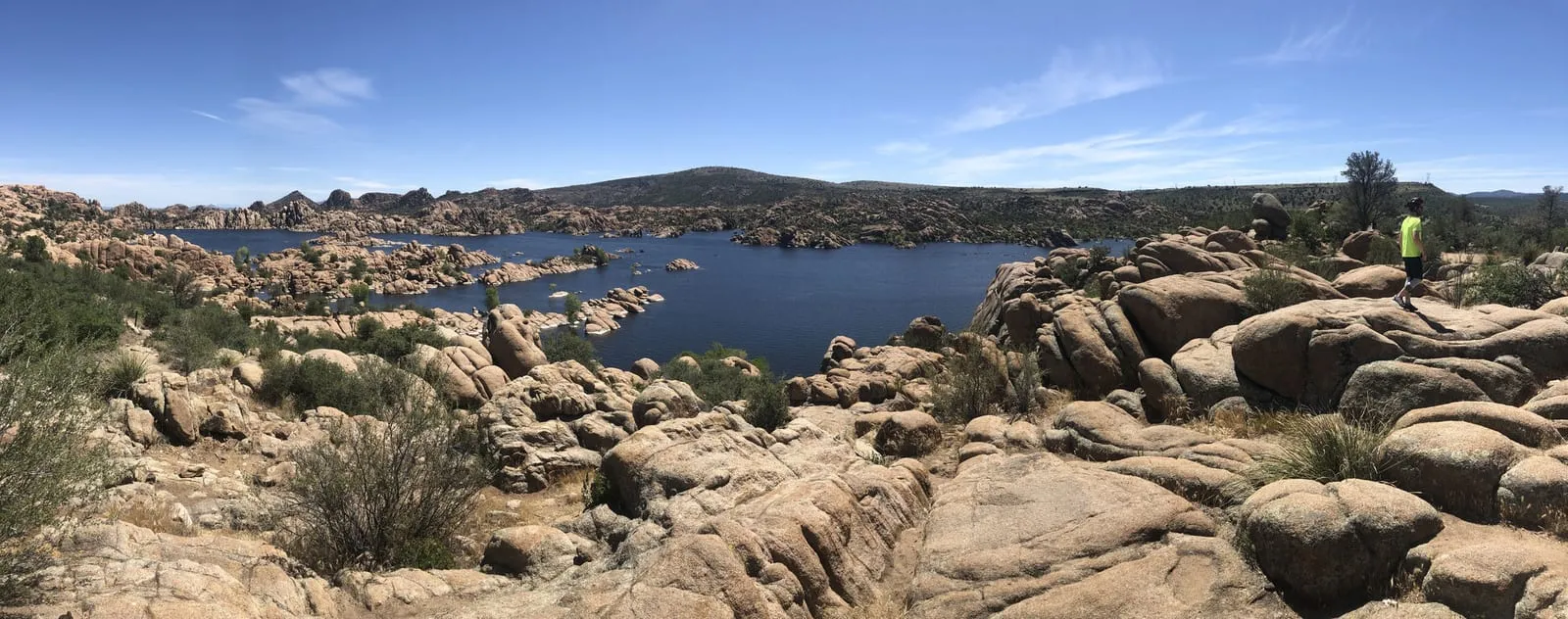 The granite boulders of the Dells tumbling into the blue water of Watson Lake